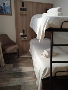 a room with two bunk beds and a chair at Hospedium Hostal Temático Desde La Judería in Arjona