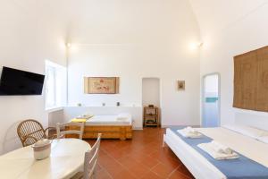 Pokój z 2 łóżkami, stołem i krzesłami w obiekcie TORRETTA CORRICELLA- Punta Serra w mieście Procida