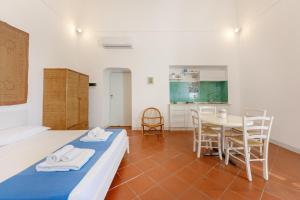 1 dormitorio con 1 cama, mesa y sillas en TORRETTA CORRICELLA- Punta Serra, en Procida