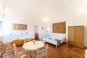 Pokój z 2 łóżkami, stołem i krzesłami w obiekcie TORRETTA CORRICELLA- Punta Serra w mieście Procida
