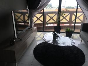a living room with a table and a balcony at The Grayish Melaka in Melaka