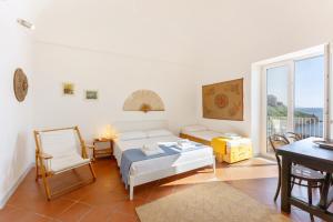 a living room with a bed and a table and a window at TORRETTA CORRICELLA- Punta dei Monaci in Procida