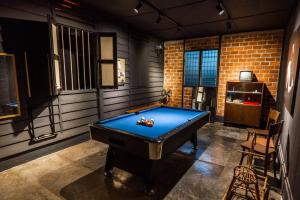 a pool table in a room with a brick wall at Kluang Swimming Pool Blues 11 Retro Homestay in Kluang