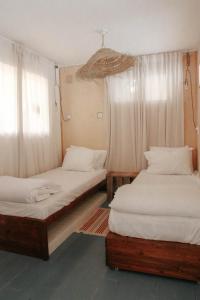 a room with two beds and a window at Jasmine House in Amirim +51 photos