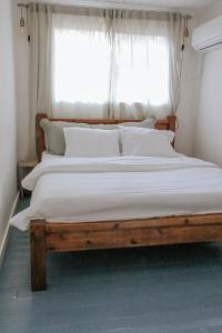 a large bed in a bedroom with a window at Jasmine House in Amirim