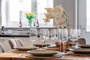 einen Tisch mit Weingläsern und eine Vase Blumen in der Unterkunft Modern 3 bedroom spacious house with parking in Bath