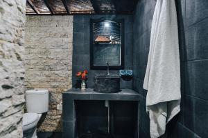 a black bathroom with a sink and a toilet at Tunjung Sari Villa Bedugul in Bedugul