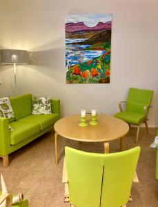 a living room with a couch and a table and a painting at Kuttainen Lodge in Karesuando