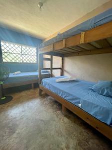 een slaapkamer met 2 stapelbedden en een raam bij Johnnys Place Hotel in Monterrico