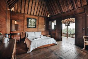 um quarto com uma cama num quarto com paredes de madeira em Tunjung Sari Villa Bedugul em Bedugul