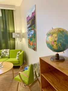 a living room with a green couch and a globe at Kuttainen Lodge in Karesuando