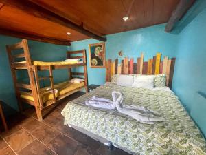 a bedroom with a bed and two bunk beds at Johnnys Place Hotel in Monterrico