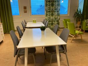 two tables and chairs in a room with windows at Kuttainen Lodge in Karesuando