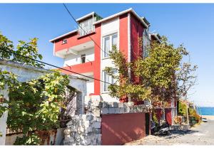 a red and white building on the side of a street at İstanbul havaalanına10 dk olan oda in Arnavutköy