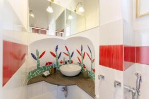 uma casa de banho com um lavatório branco e azulejos vermelhos e brancos. em TORRETTA CORRICELLA- Torretta em Procida