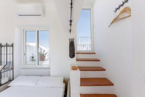 a staircase in a white room with a white couch at TORRETTA CORRICELLA- Torretta in Procida