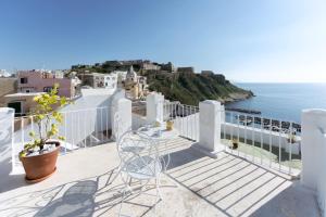 a balcony with a table and chairs and the ocean at TORRETTA CORRICELLA- Torretta in Procida