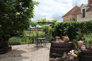 un jardin avec une table, une chaise et des plantes dans l'établissement Les hirondelles du moulin, à Sassay