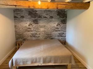 Ce lit se trouve dans une chambre dotée d'un mur en briques. dans l'établissement Cosy Cott, een verborgen logeerplek in het landelijke Poeke., à Aalter