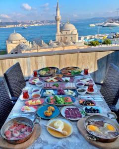 una mesa con platos de comida en la parte superior de un balcón en White Suites Hotel İstanbul, en Estambul