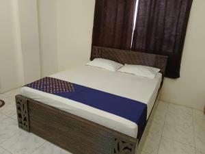 a bed with a wooden headboard in a room at Bhavani Residency in Dapoli