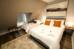 a bedroom with two beds with orange pillows and a rug at Entire Cozy House near Moody St, Bentley, Brandeis in Waltham