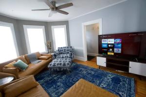 a living room with a couch and a flat screen tv at Entire Cozy House near Moody St, Bentley, Brandeis in Waltham