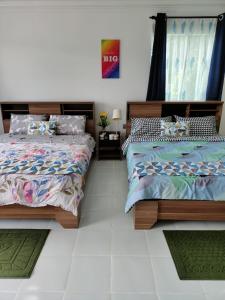 two beds sitting next to each other in a bedroom at Sunrise Bedrooms and Transit in Ranau