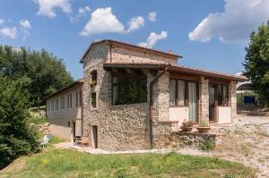 un pequeño edificio de piedra en medio de un campo en FAETOLE typical Tuscan country house near FLORENCE, en Capannuccia