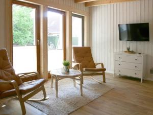 a living room with two chairs and a table and a tv at Apartments im Schwedenstil in Papenburg