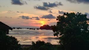 a sunset on a beach with the sun setting at Bhavani Residency in Dapoli