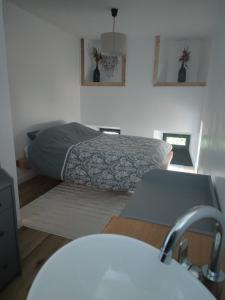 ein Schlafzimmer mit einem Bett in der Ecke eines Zimmers in der Unterkunft Appartement centre-ville de Valognes in Valognes