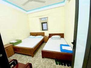 a room with two beds and a window at Nhà nghỉ Tâm Cường in Diện Biên Phủ