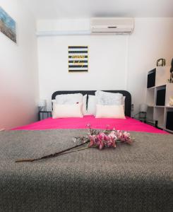 Un dormitorio con una cama rosa con flores rosas. en Apartments Mary & Private FREE PARKING en Rovinj