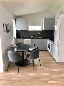 a kitchen with a table and chairs and a refrigerator at Cottage by the river in Avesta