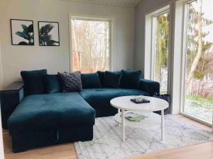 a living room with a blue couch and a table at Cottage by the river in Avesta