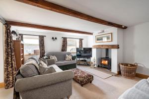 a living room with a couch and a fireplace at Bilberry Bank Cottage in Holmfirth