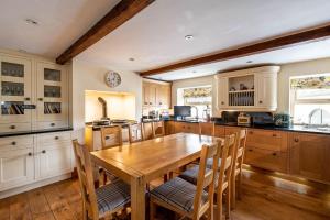 uma grande cozinha com uma mesa de madeira e cadeiras em Bilberry Bank Cottage em Holmfirth
