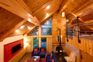 a living room with blue chairs and a fireplace at Renest River Country Resort Manali in Manāli