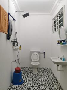 a bathroom with a toilet and a sink at Sunrise Bedrooms and Transit in Ranau
