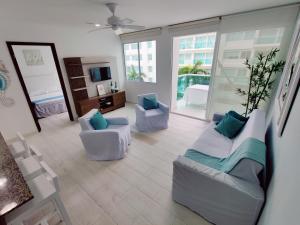 een grote woonkamer met 2 stoelen en een bank bij Apartamento con vista al mar in Cartagena