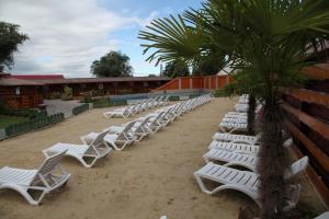a row of white lounge chairs on a beach at Hotel Karczma u Macieja in Bolków