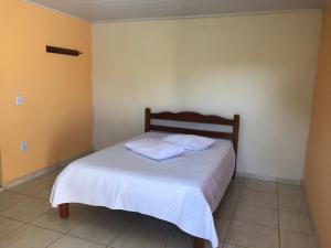 1 dormitorio con 1 cama con 2 almohadas en Pousada Catarinense, en Chapada dos Guimarães