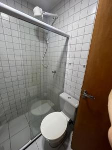 y baño blanco con aseo y ducha. en Flat em Gravatá Monte Castelo, en Gravatá