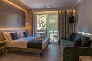 um quarto de hotel com uma cama e um sofá em Nicole Studios em Agia Effimia