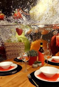 - une table en bois avec des assiettes et des verres à vin dans l'établissement Kikötő Sétány Apartman I., à Balatonszemes