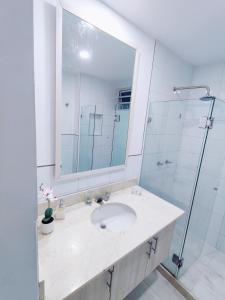 een badkamer met een wastafel en een douche bij Apartamento con vista al mar in Cartagena