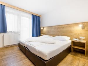 Schlafzimmer mit einem großen Bett mit einem Kopfteil aus Holz in der Unterkunft Apart Corona in Sölden