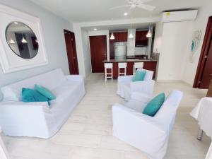 een woonkamer met 2 witte banken en een keuken bij Apartamento con vista al mar in Cartagena