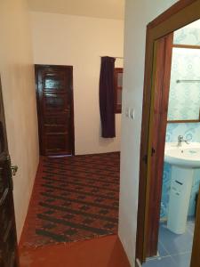 pasillo con lavabo y puerta al baño en Guest House Imdoukal, en Aït Tamellil